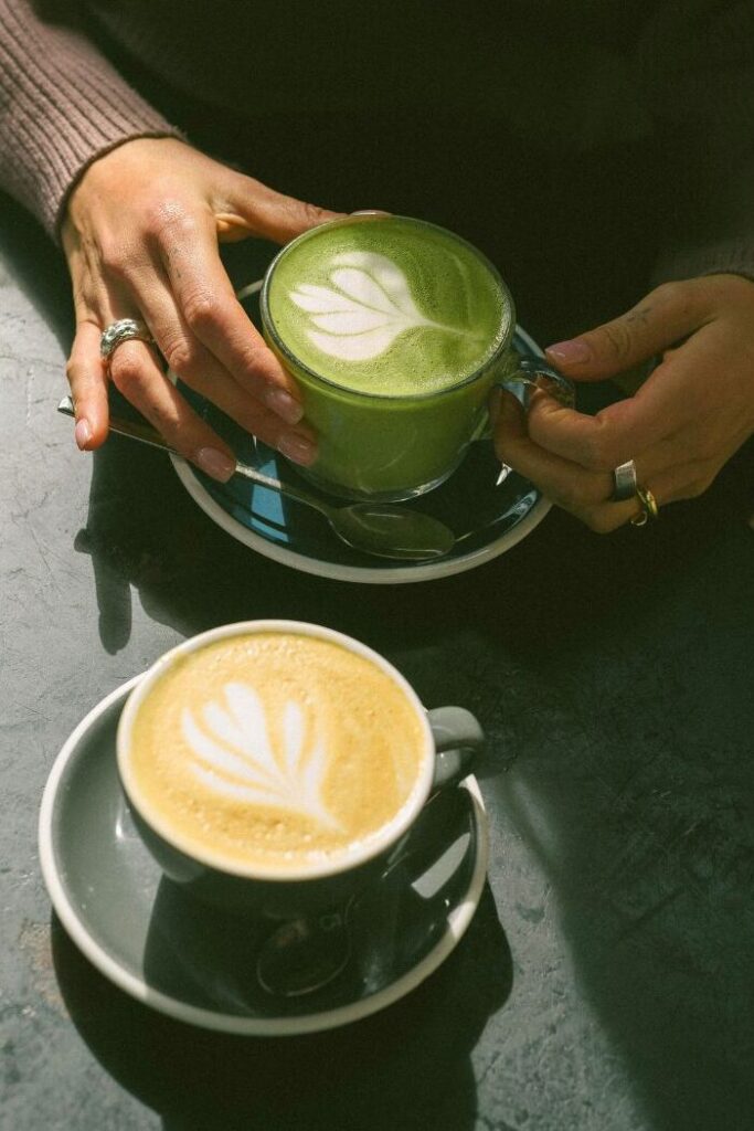 Matcha latte és kávé latte egymás mellett az asztalon, összehasonlításként